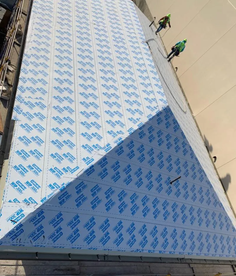 Professional roofers installing underlayment on a metal roof in Box Elder